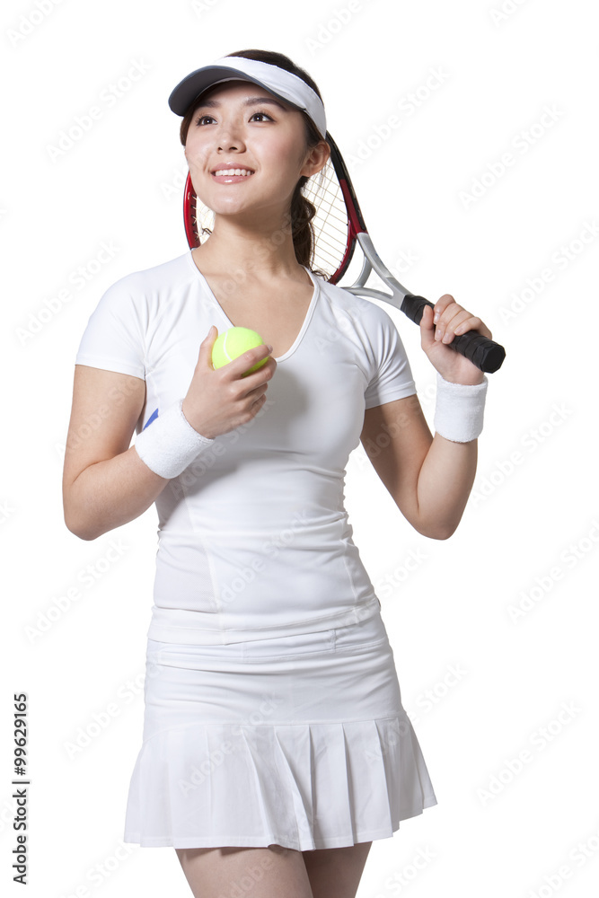 Young woman posing with tennis ball and racket