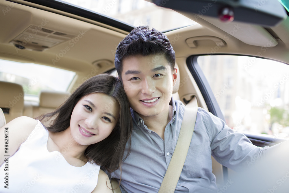 Happy young couple in a car