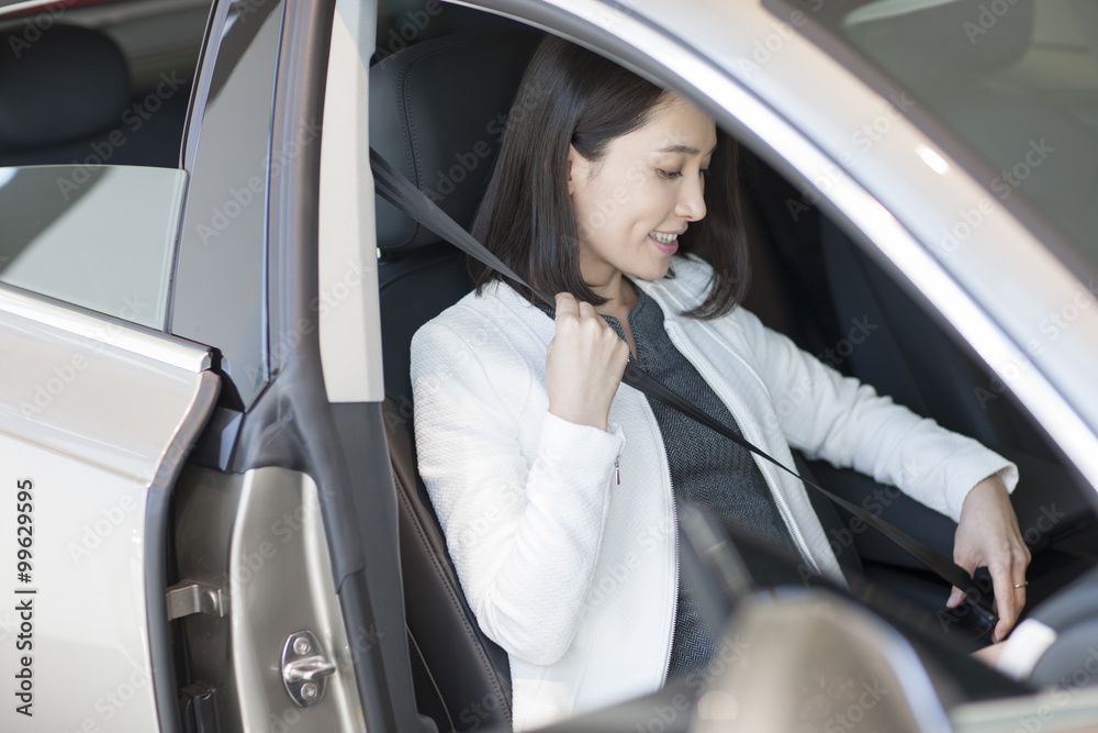 Young woman choosing car in showroom