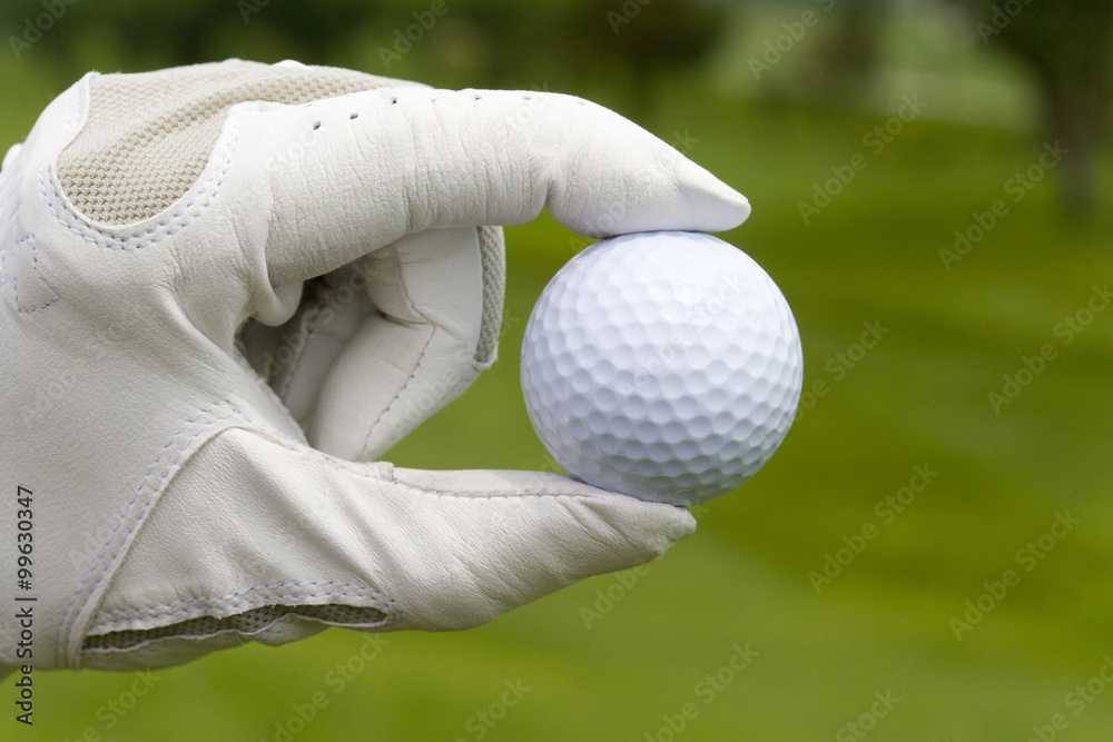 Close-up of a golf ball in golfers hand