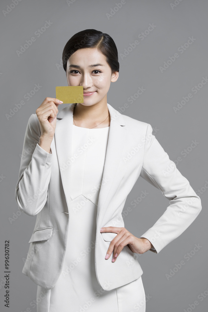 Happy young businesswoman holding a credit card