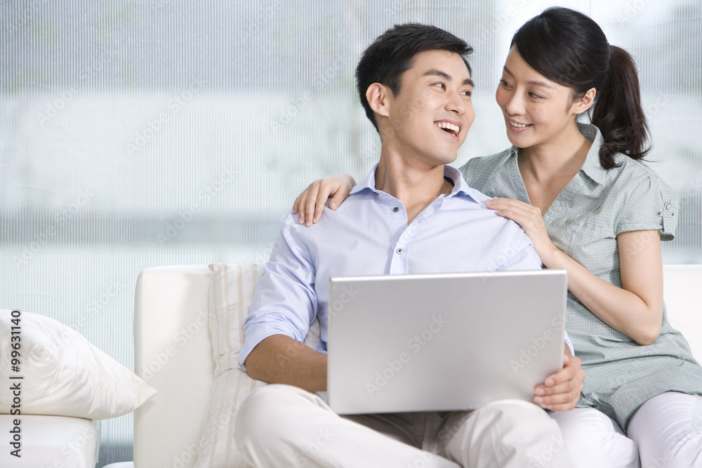 Portrait of a couple using a laptop at home