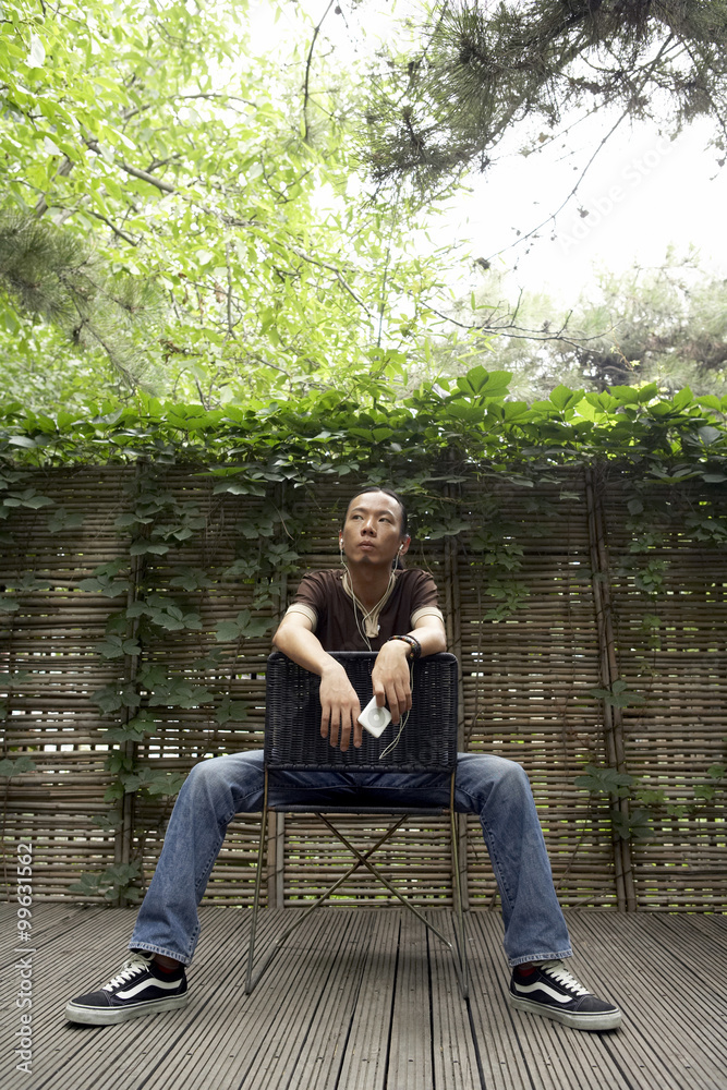 Young Man Looks To The Sky As He Sits On A Backwards Chair