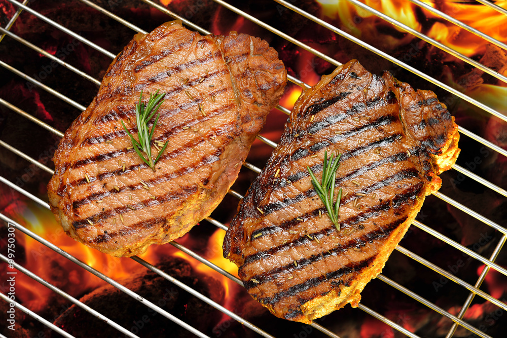 Grilled beef steaks on the flaming grill