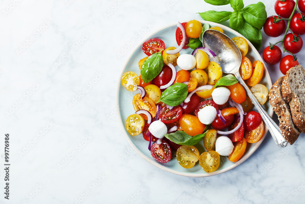 Fresh tomatoes with basil leaves in a bowl