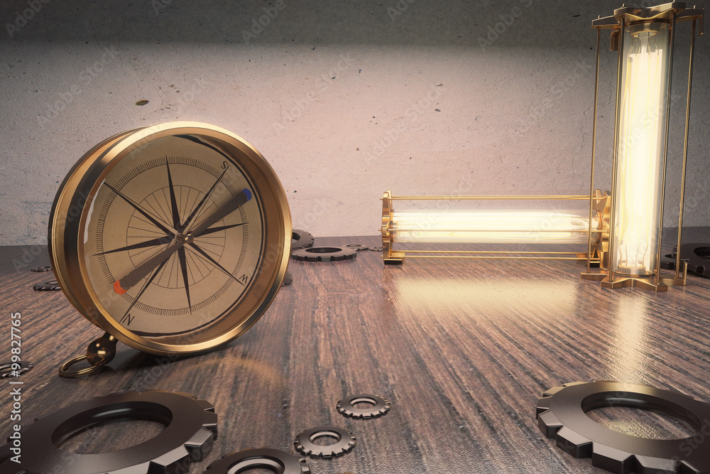 Vintage compass on a wooden table with lamps and cogs