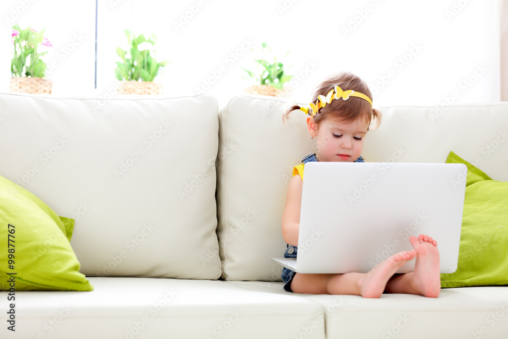 child girl with a laptop at home