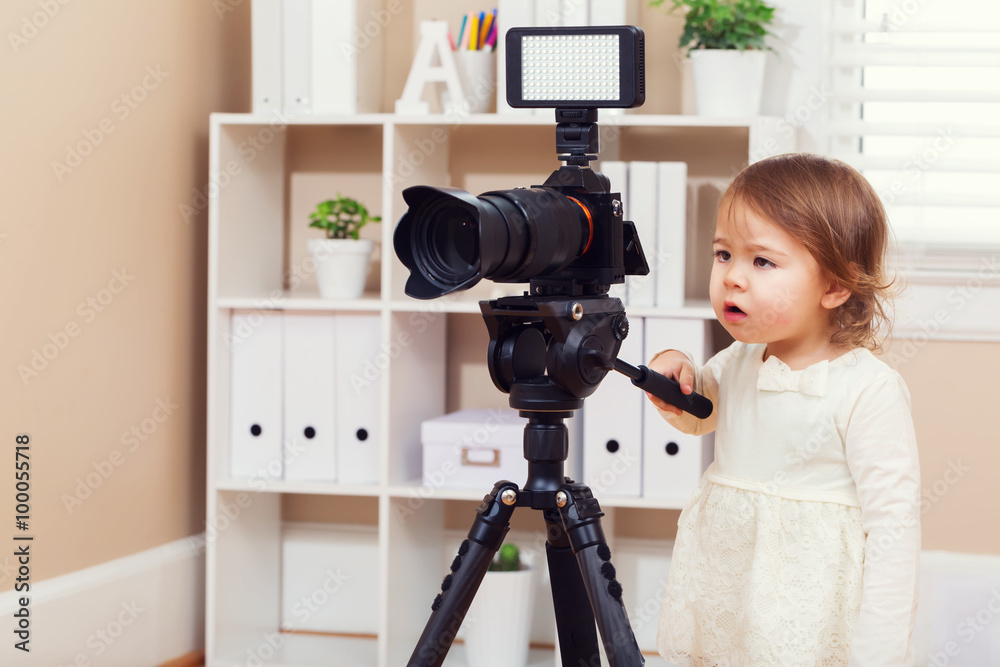 Toddler girl using a professional camera