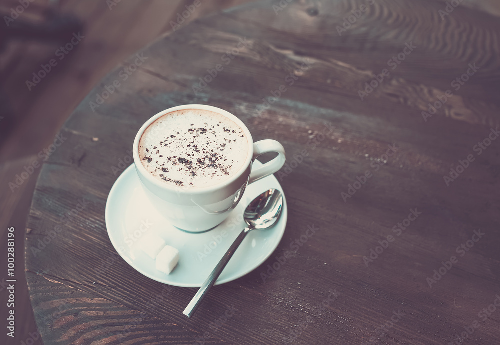 Cup of cappuccino on old dark wooden table