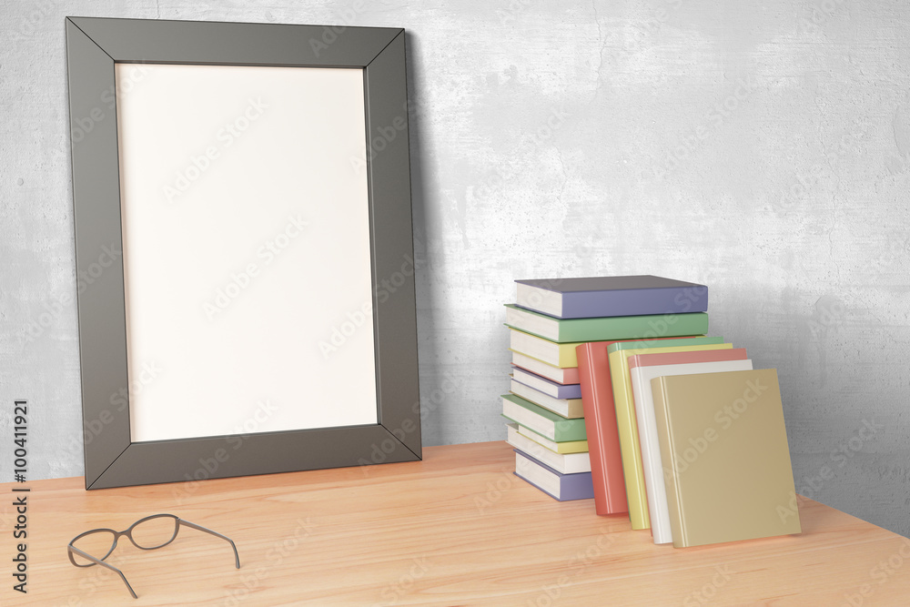 Blank grey picture frame on wooden table with eyeglasses and pil