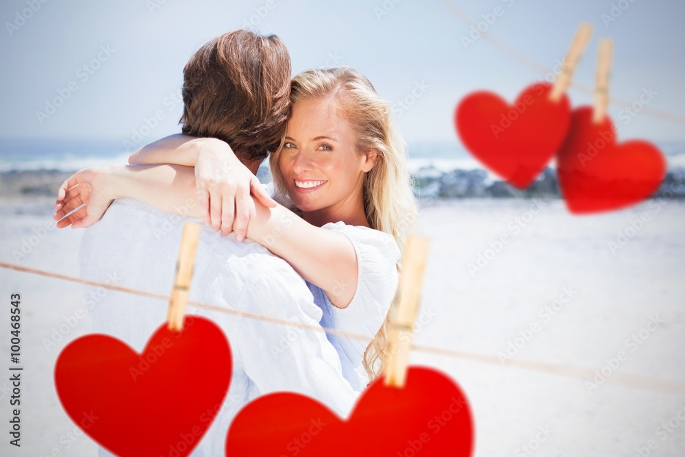 Composite image of couple embracing on the beach