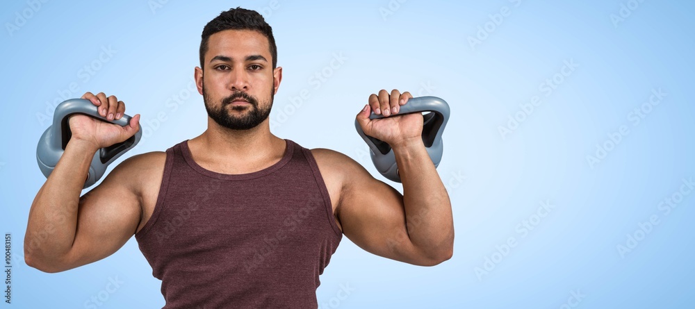 Composite image of muscular serious man lifting kettlebells