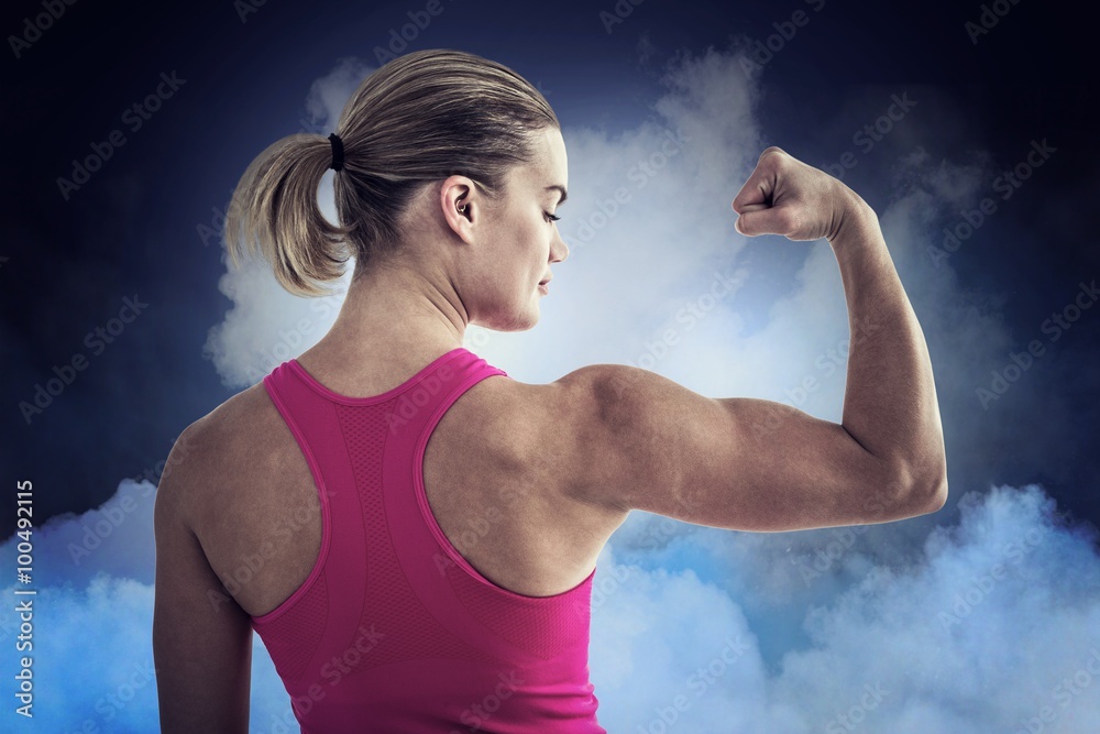 Composite image of rear view of muscular woman flexing muscles 