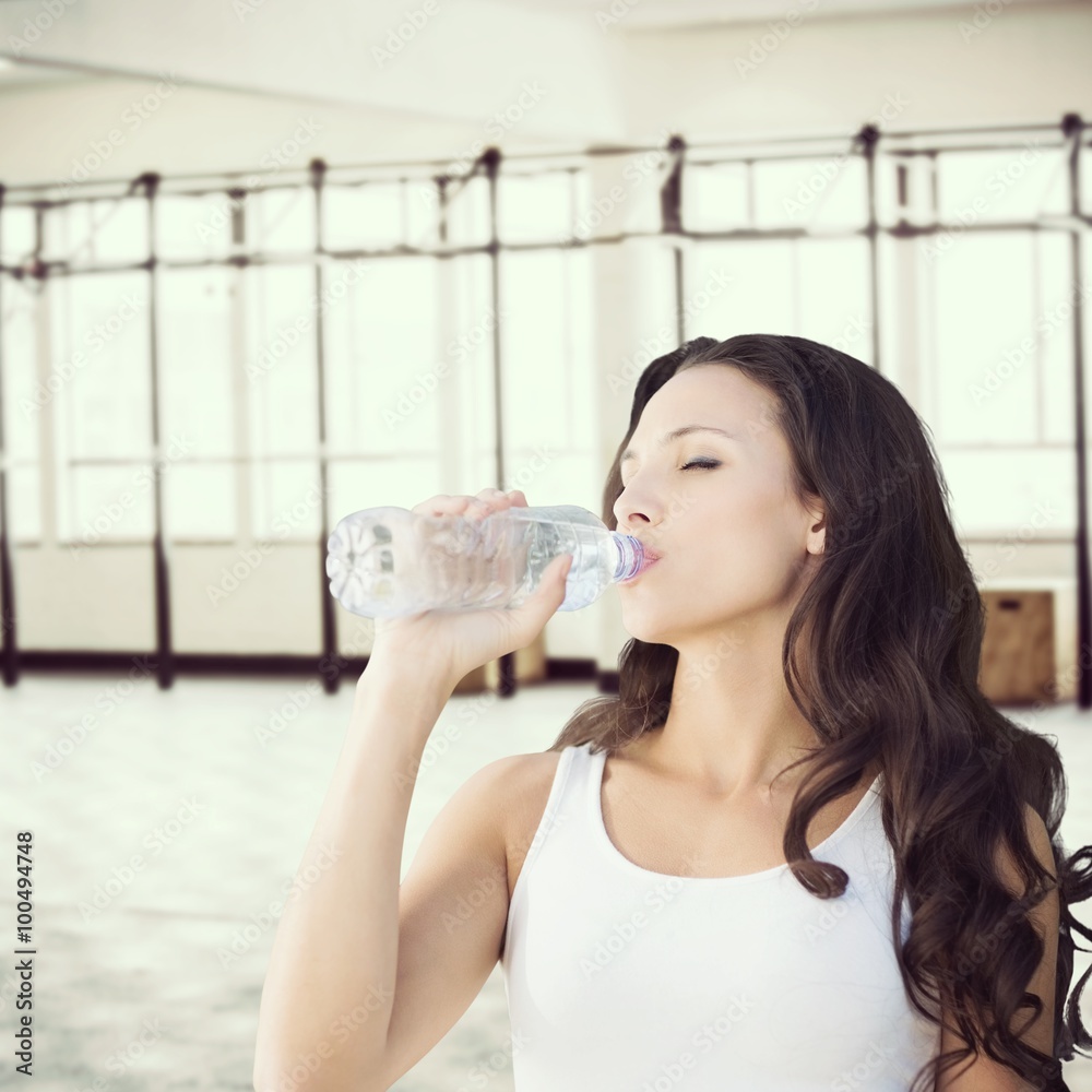 Composite image of brunette drinking water