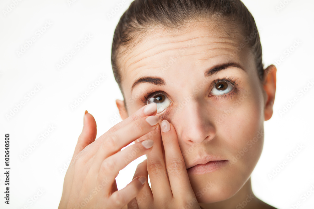 Woman putting contact lens in her eye