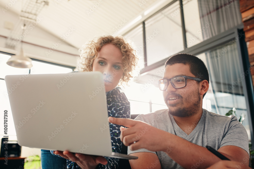 Graphic designers working in office using laptop