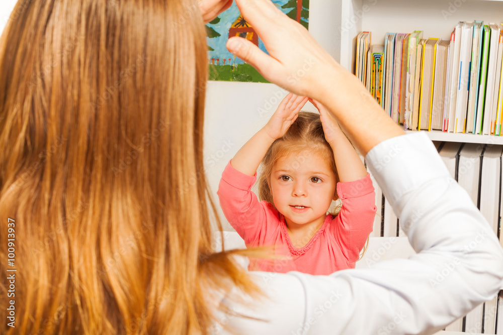 Little preschooler repeating tasks after teacher