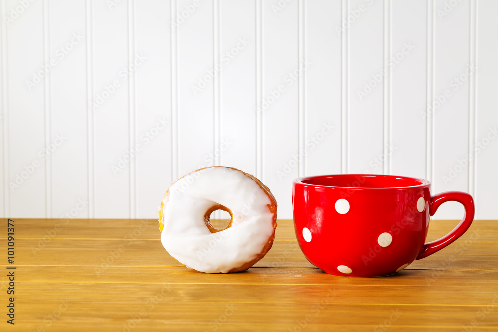 White donut with a red mug on a wooden