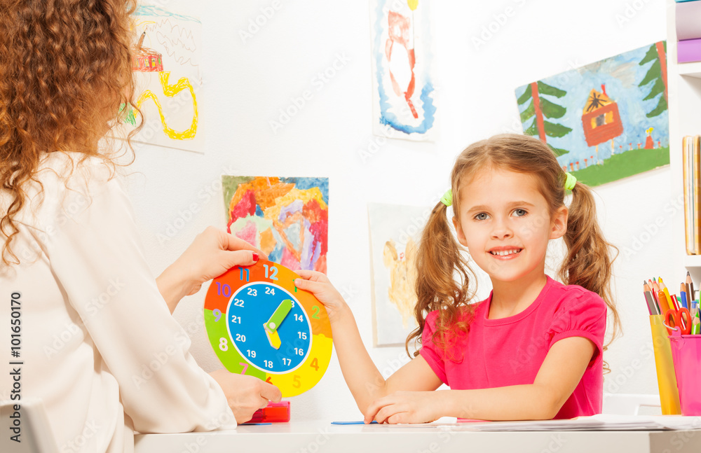 Girl studying time with the cardboard clock model