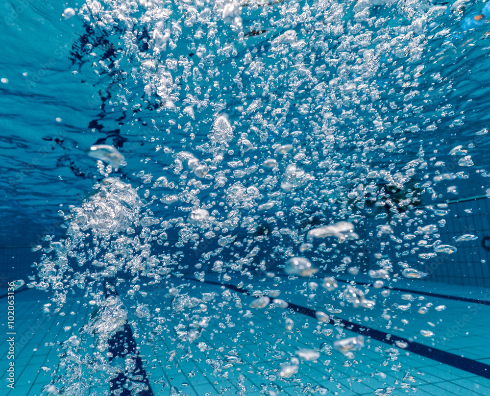 Air bubbles in clear blue water in pool