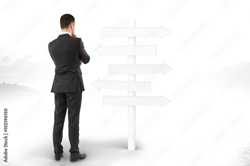 Man stands and thinks about blank signpost directions