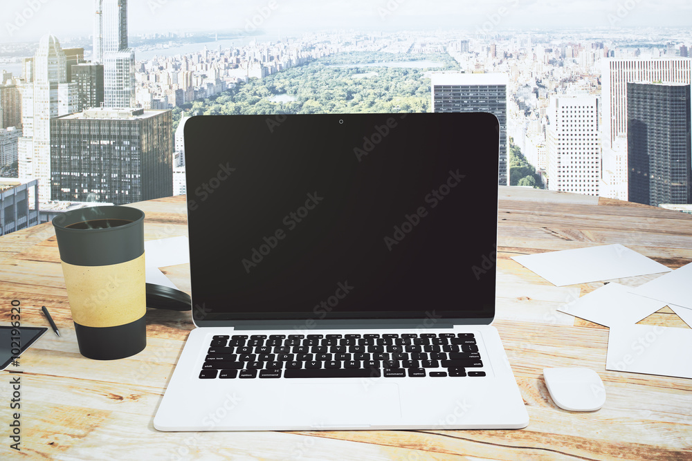 Open laptop and cup of coffee on a wooden table