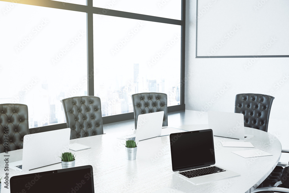 Boardroom with white table and black chairs