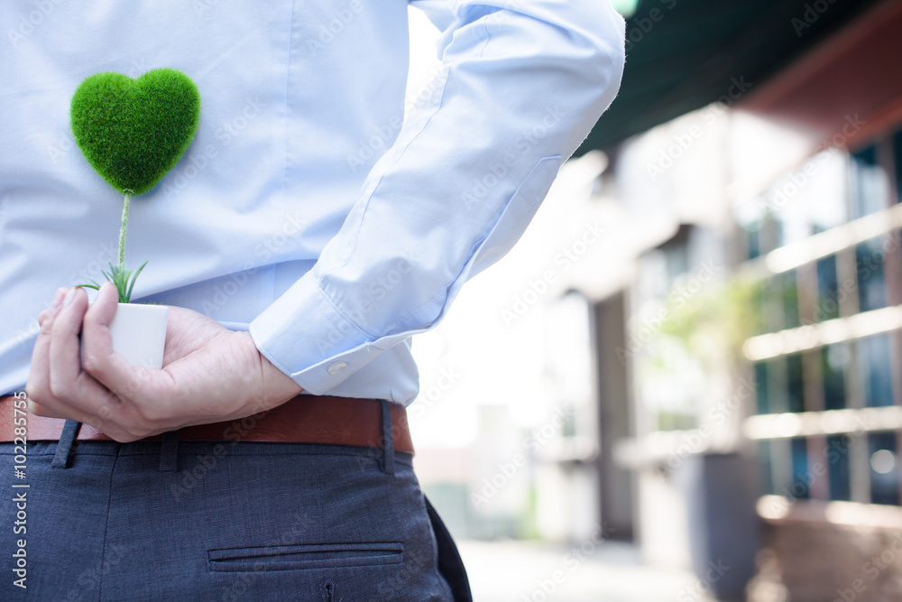 Man hands holding surprise gift from behind - love and relationship concept