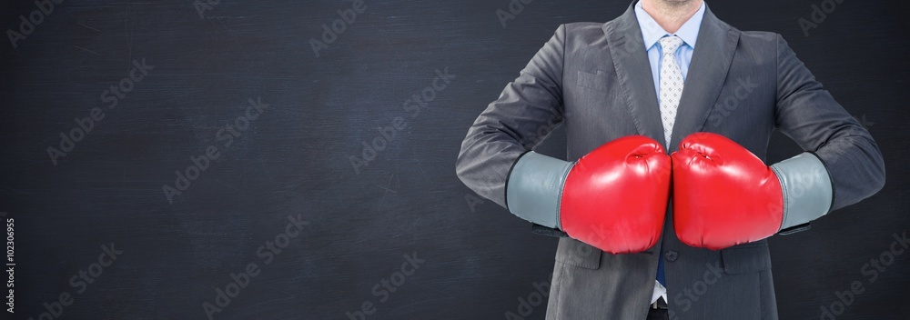 Composite image of businessman with boxing gloves