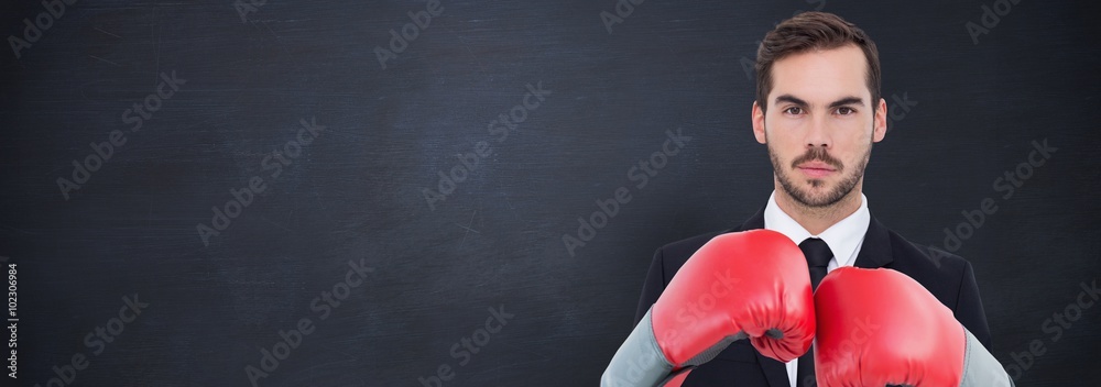 Composite image of businessman with boxing gloves