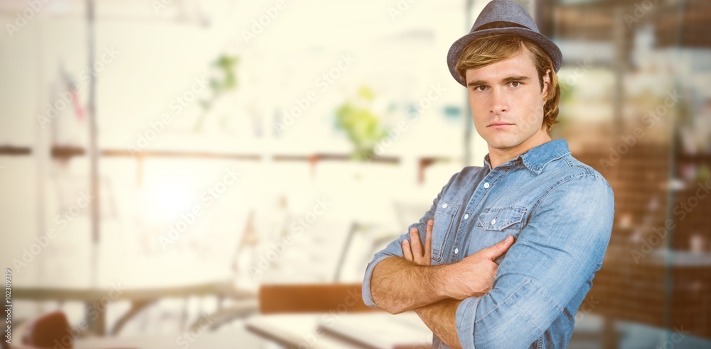 Composite image of serious hipster crossing his arms