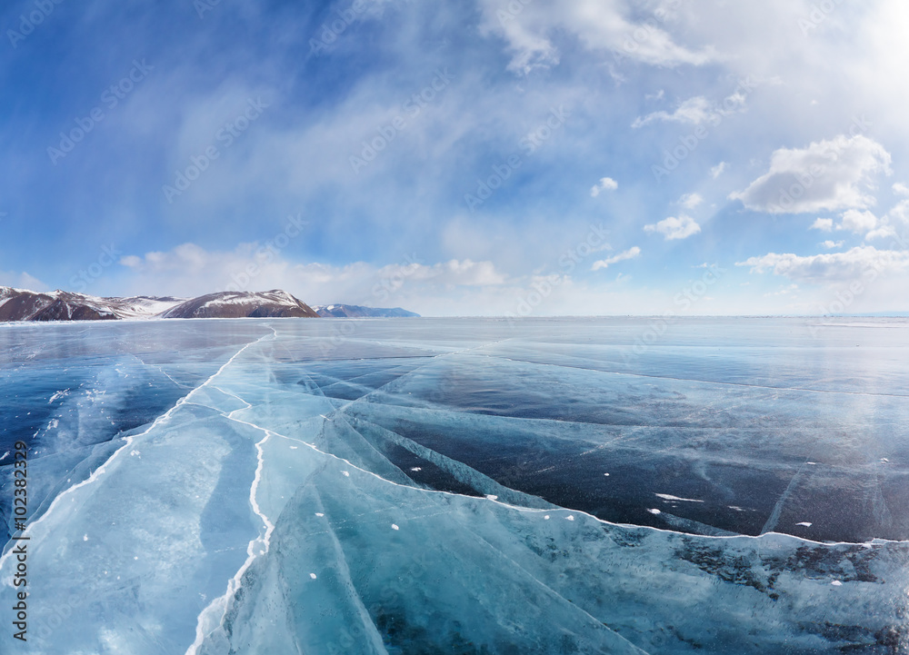 Winter ice landscape on Siberian lake Baikal with clouds