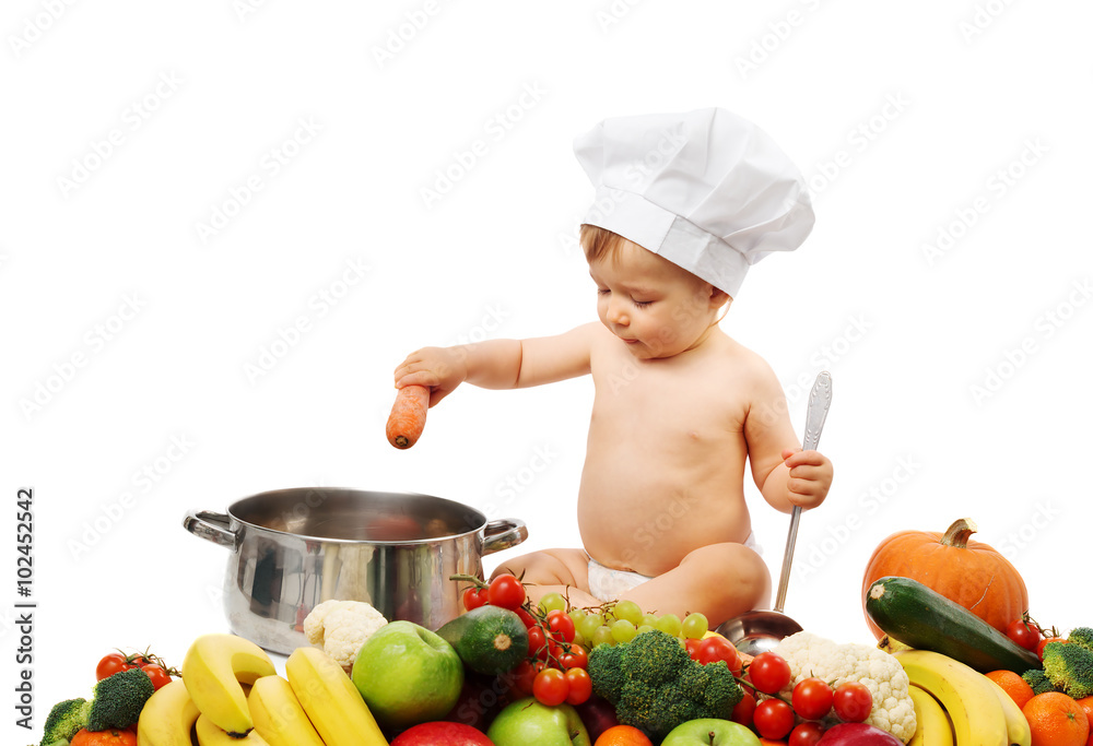 Baby boy in chef hat with cooking pan and vegetables