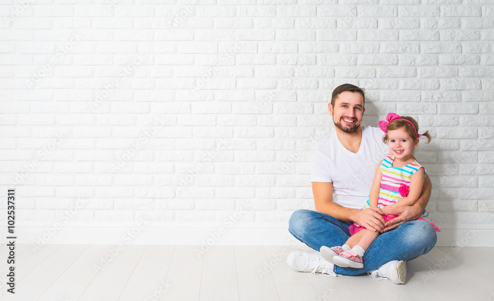 Family father child daughter at a blank white brick wall