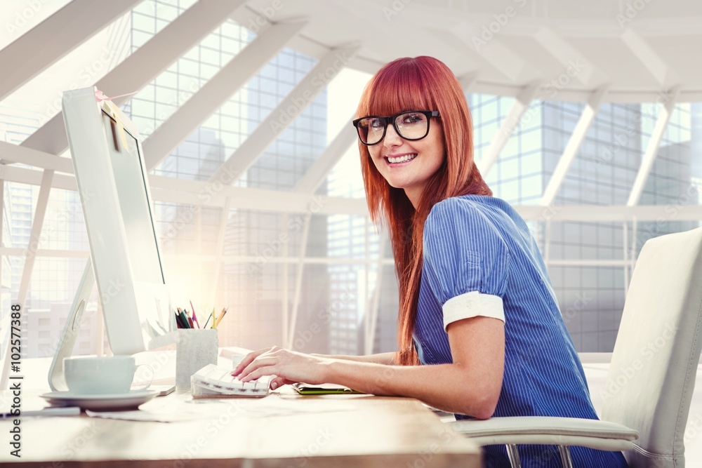 Composite image of smiling hipster woman typing on keyboard 