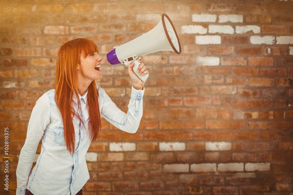 Composite image of hipster smiling woman through megaphone