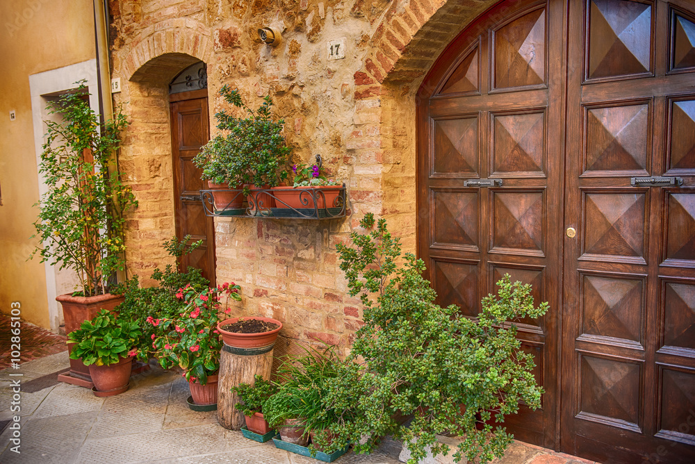 View of the ancient old european city. Street of Pienza, Italy with wooden doors.