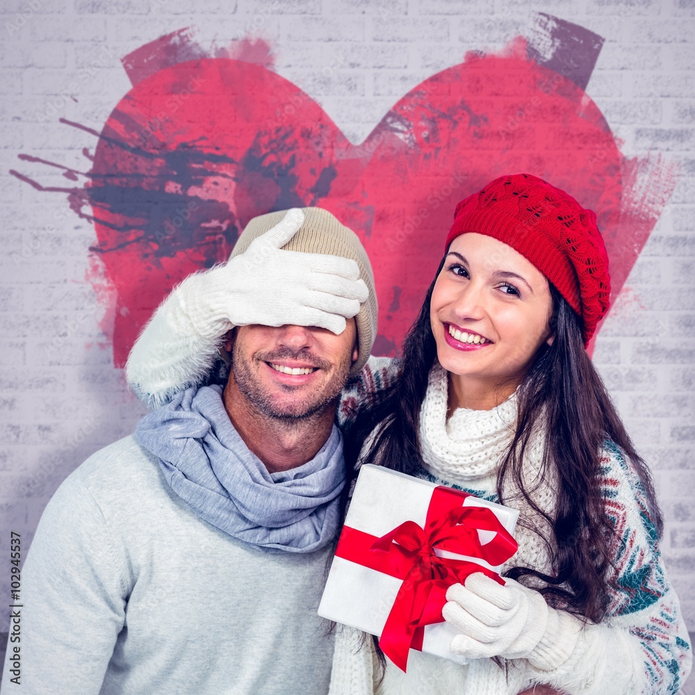 Composite image of smiling woman covering partners eyes