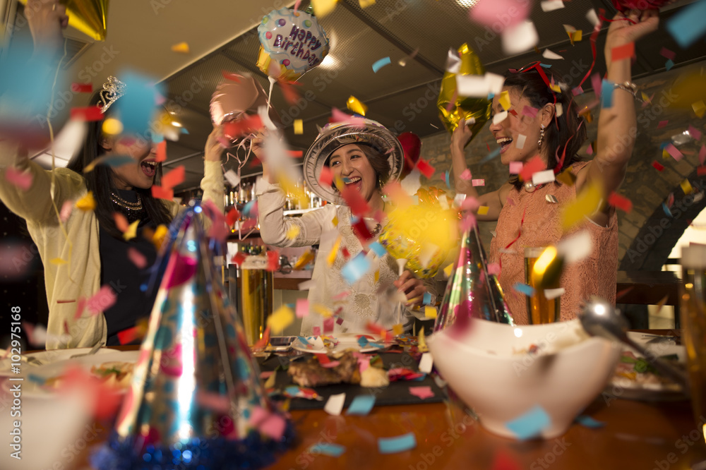 三个女人在五彩纸屑中庆祝生日