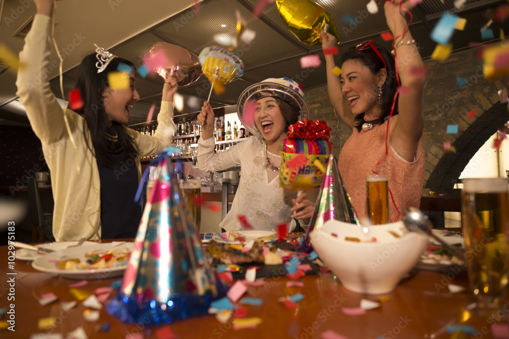 五彩纸屑中的三个女人，庆祝生日