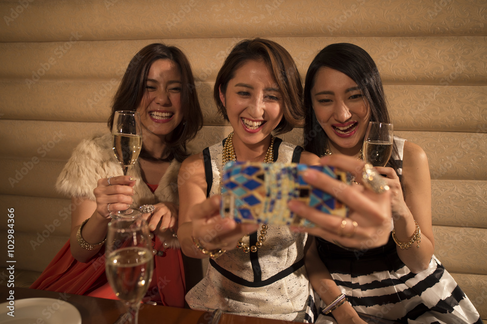 Three women have taken on a smartphone with a champagne