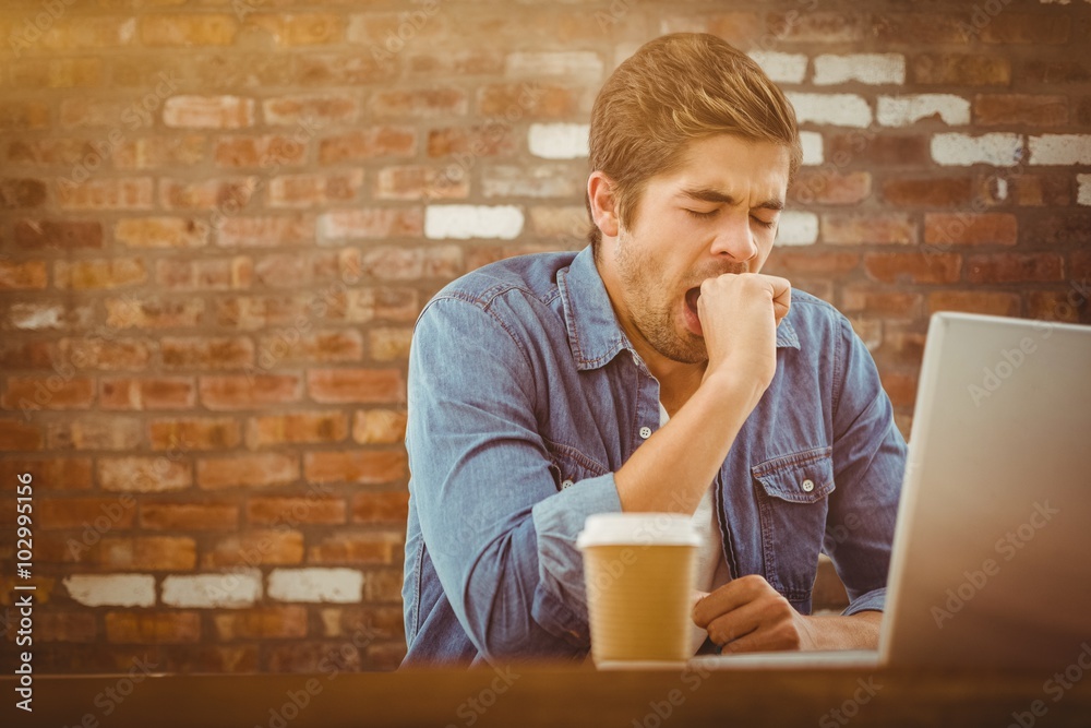 Composite image of tired businessman sitting at desk