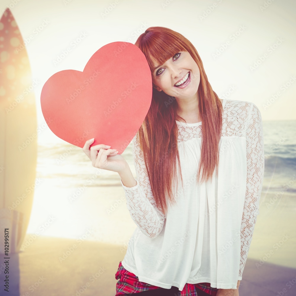 Composite image of smiling hipster woman with a big red heart