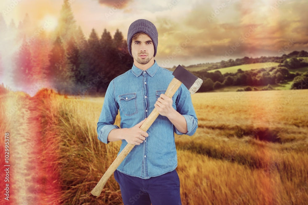 Composite image of portrait of serious hipster holding axe