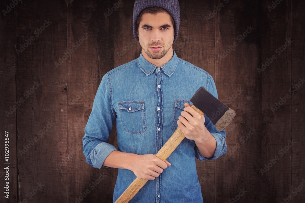 Composite image of serious hipster holding an axe