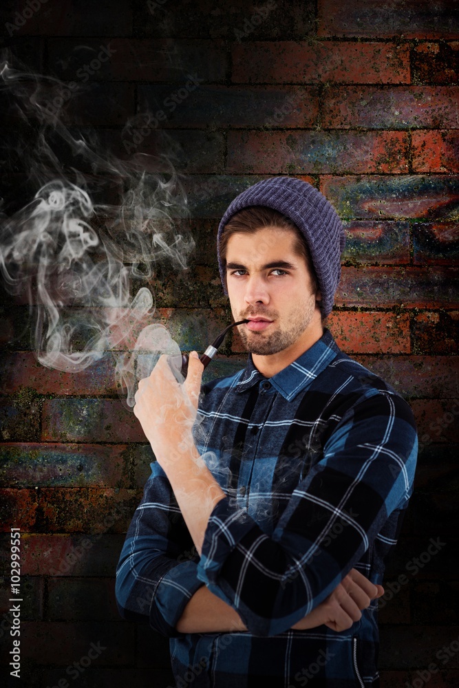 Composite image of portrait of hipster holding smoking pipe