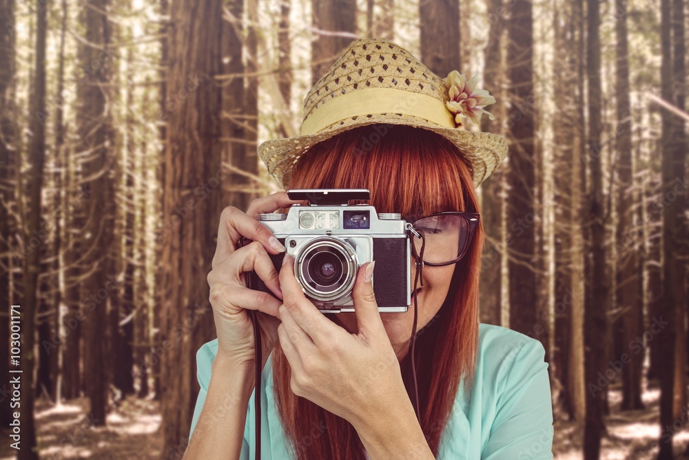 Portrait of a smiling hipster woman holding retro camera