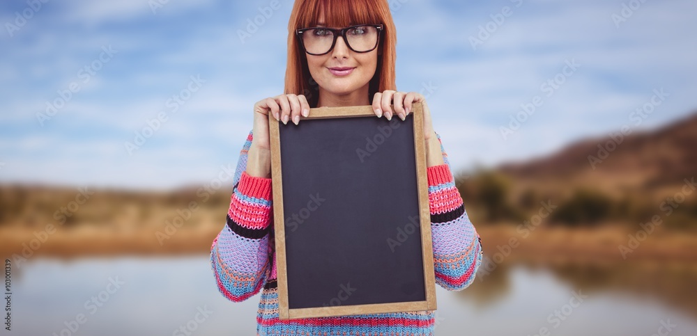 微笑的潮人女人拿着黑板的合成图像