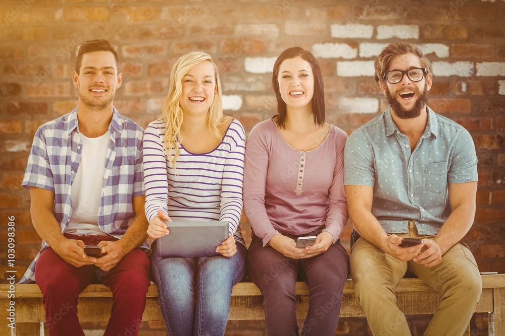 Composite image of smiling business people holding electronics