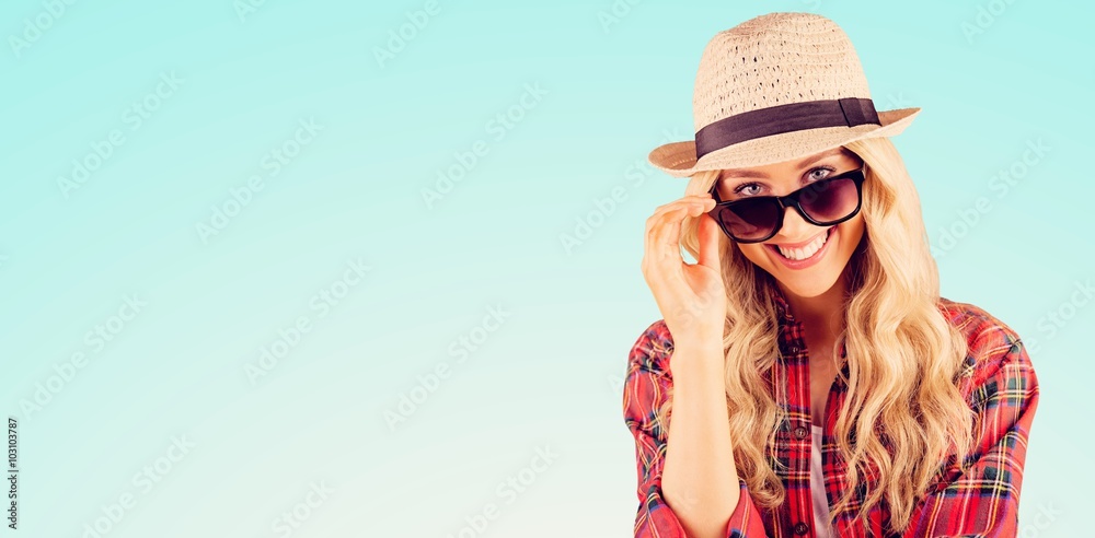 Composite image of gorgeous smiling blonde hipster posing with sunglasses